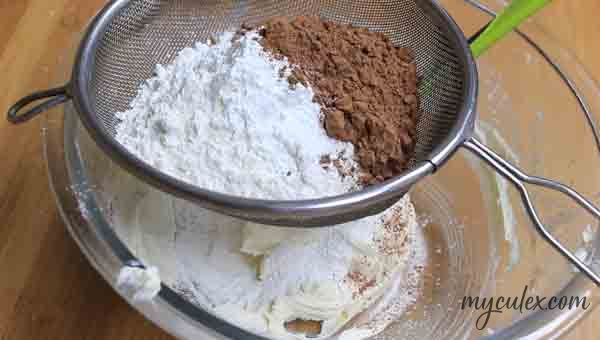 10. Sift & add flour, cornflour, cocoa pdr, baking powder, baking soda & salt.
